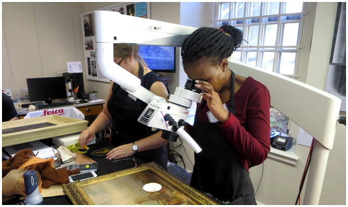 Click the image for a view of: GC examining the painting using the new stereo microscope
possible by Yentl Kohl, Iziko Education.